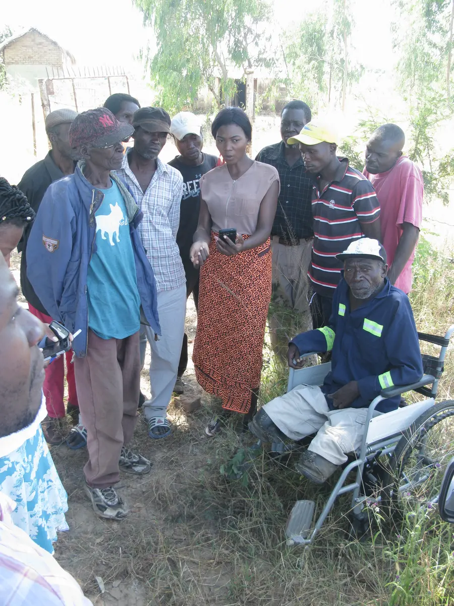 A field researcher demonstrates a smartphone app to a group of participants